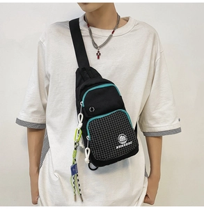 Detail view of water-resistant street style chest bag with black and cyan grid patterns