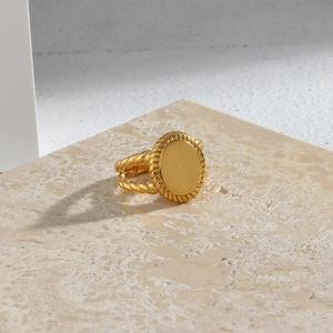 Detailed view of 18K gold-plated stainless steel ring with oval top and braided band texture