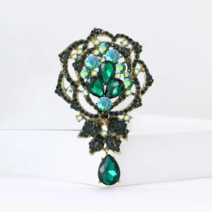 Elegant gold vintage brooch with green teardrop rhinestones and floral hollow design