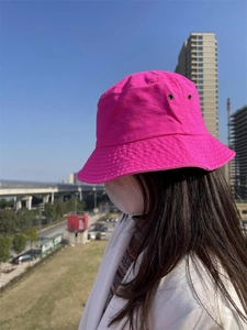 Detail of rose red cotton bucket hat with metal eyelets and stitched brim for women
