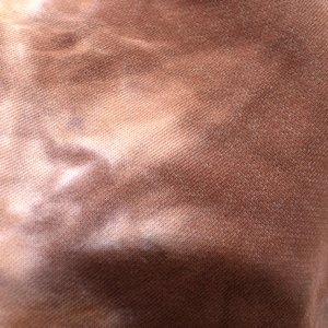 Macro shot of brown tie-dye knit fabric texture with roll-edge beanie material detail