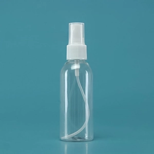 Macro shot of a clear PET spray bottle with a white pump head and a transparent dust cap