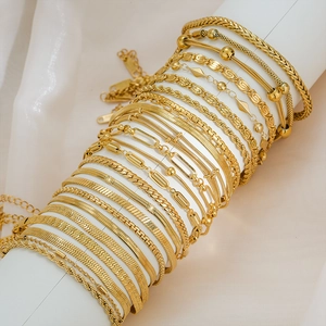Minimalist 18K gold plated titanium steel chain bracelet set displayed on a white stand
