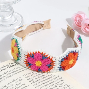 Detail of handmade knit floral headband with colorful 3D crochet flowers on white wool