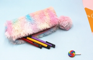 Detailed macro shot of fuzzy rainbow plush pencil case with large pompom zipper pull