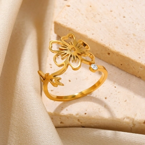 Macro detail of gold flower ring with leaf design and a single zircon stone inlay