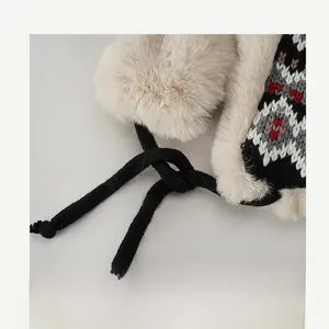 Détail du bonnet d'hiver avec bordure en fausse fourrure beige et motifs jacquard