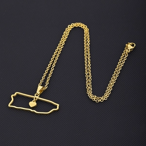 Detail view of Puerto Rico map pendant in gold finish with heart cutout on black background