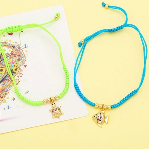 Macro detail of hand-woven bracelets with colorful turtle and fish crystal pendants