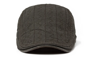 Detail of dark brown cotton flat cap showing fabric texture and wavy stitching pattern