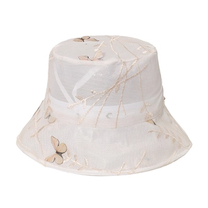 Détail d'un chapeau bob en maille blanche avec broderie papillon jaune délicate
