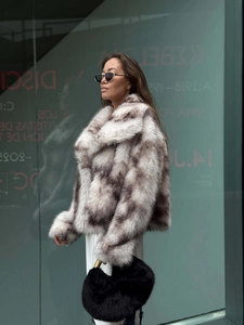 Close-up of mottled grey faux fur texture and wide collar on short winter coat