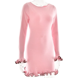 Detail of pink knitted mini dress featuring ruffle cuffs and dark contrasting edges