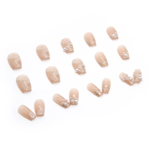 Elegant nude pink press-on nails with marble texture, gold foil accents and pearls