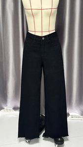 Gros plan sur le jean noir taille haute à jambes larges avec détails d'ourlets bruts
