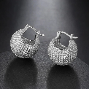Detail view of silver pave ball earrings with shimmering white cubic zirconia stones