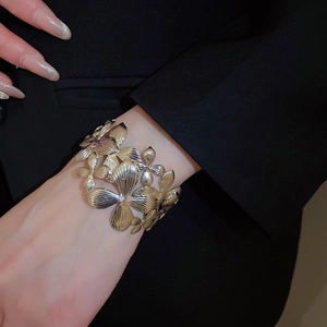 Détail d'un bracelet manchette floral artistique avec texture de pétales brossés sur modèle