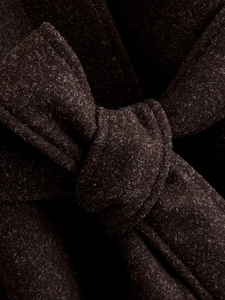 Macro shot of dark brown wool coat fabric texture and belted knot craftsmanship details