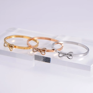 Polished bow cuff bracelets in gold, silver, and rose gold with sparkling zirconia accents