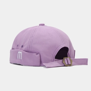 Detailed side view of lavender canvas docker hat with white m embroidery and metal buckle