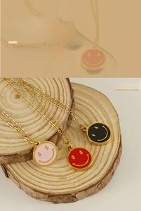 Détail de colliers en acier doré 18K avec smileys en émail rose, rouge et noir