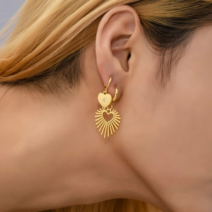 Detailed view of 18K gold heart earrings with zircon studs on a female model
