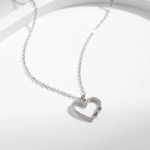 S925 silver heart necklace with infinity symbol and pave set stones on white background