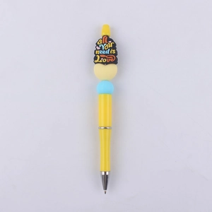 Detail of yellow beaded ballpoint pen with 'all you need is Love' silicone decoration