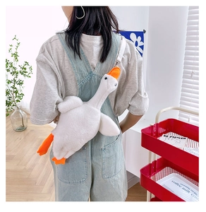 Detailed back view of a plush white goose crossbody bag worn by a model in a room