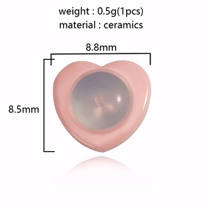 Macro view of pink heart-shaped ceramic earring backs with precise dimension specs