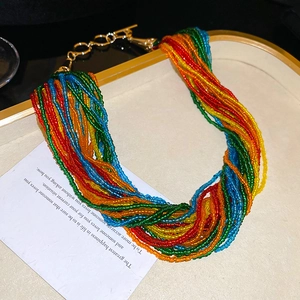 Dettaglio di strati di perline colorate bohémien e chiusura OT dorata su vassoio