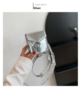 Detail view of mini silver metallic belt bag with shiny finish and thin shoulder strap