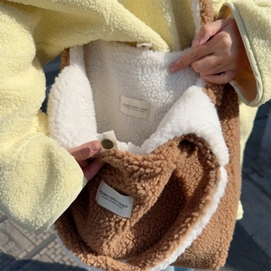 Detail of soft brown plush tote bag with cozy faux fur texture and metal snap button