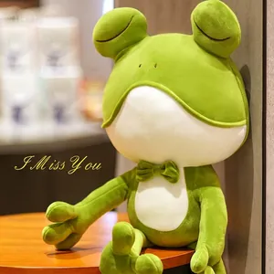 Cute green frog plush toy wearing a hood sitting on a wooden table for home decor