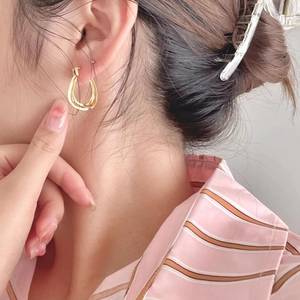Elegant 925 sterling silver irregular gold hoop earrings worn by a model in soft light