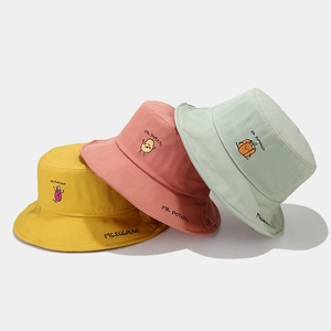 Three cotton bucket hats in yellow, pink, and green with cute vegetable embroidery