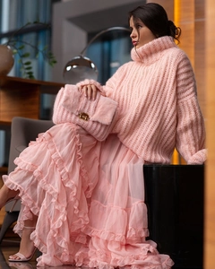 Pink chunky turtleneck knit sweater paired with tiered ruffle skirt and faux fur clutch