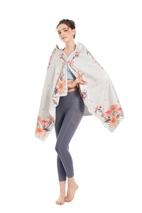 Detail of microfiber beach towel featuring large warm floral print draped on model