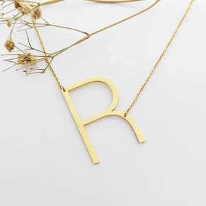 Collier minimaliste en acier inoxydable doré 18 carats avec pendentif lettre R, fond blanc