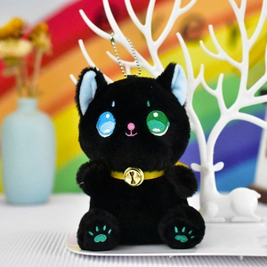 Close-up detail of a black plush cat keychain with heterochromia eyes and golden bell