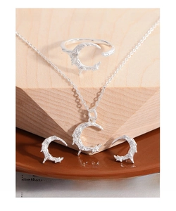 Detail showing moon-shaped S925 silver jewelry set with zircon and textured surface