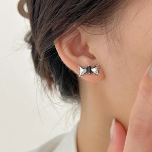 Close-up of a 925 sterling silver bow earring with a rectangular black zircon gemstone