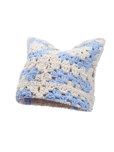 Macro detail of blue and beige crochet knit winter hat featuring cute cat ear design