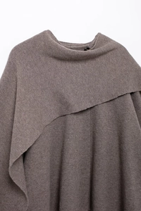 Detailed close-up of the asymmetrical neckline on this brown knit shawl cloak cardigan