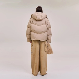 Back view of a khaki wide-cut down jacket with hood showing the silhouette and outfit style