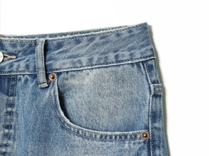 Detailaufnahme des Jeans-Bunds mit Gürtelschlaufen und Nieten aus Kupfer in Blau