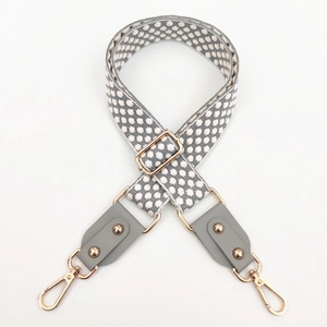 Détail de la bandoulière tissée réglable avec embouts en cuir et mousquetons dorés