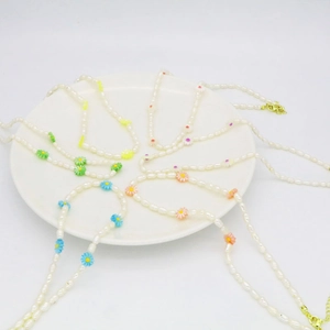 Detailed view of freshwater pearl necklace with colorful flower charms and gold lobster clasp