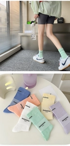 Detailed view of pastel ribbed cotton socks set with embroidered logo in multiple colors