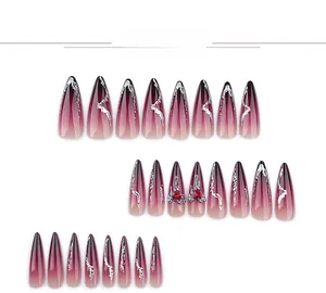 Detail of stiletto press-on nails with wine red gradient, 3D fluid lines and heart gems